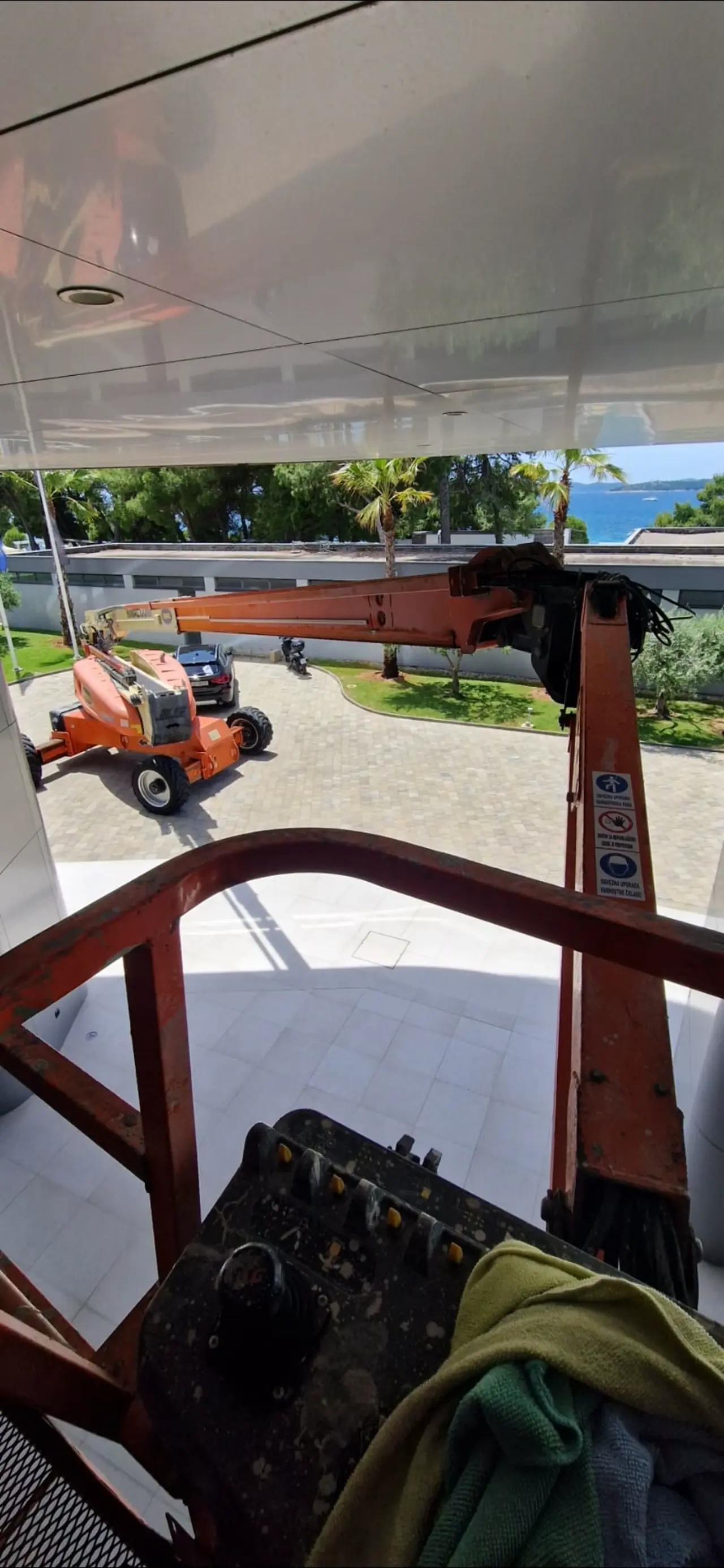 Pogled s hidraulične platforme tijekom pranja staklenih površina na zahtjevnim visinama – profesionalni visinski radovi Clean & Clear.