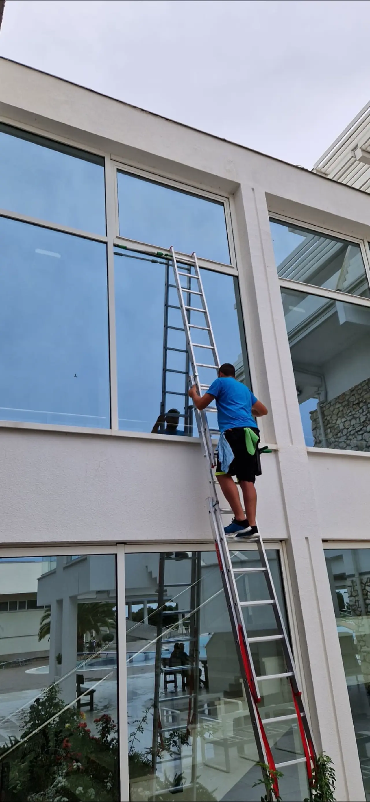 Djelatnik servisa Clean & Clear precizno pere staklene površine na ljestvama, osiguravajući vrhunsku čistoću poslovnog objekta u Zagrebu.
